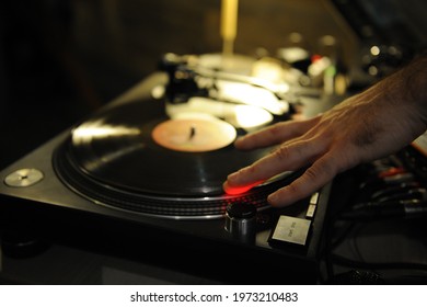 DJ Plays Live Set And Mixing Music On Turntable In The Night Club. Station At Club Party. DJ Mixer Controller Panel For Playing Music And Partying.