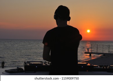 DJ Plays Music On The Beach At Sunset