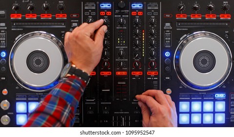 DJ In The Process Of Work. Men's Hands Are Played On The Mixing Console. Top View