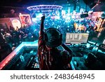 A DJ shouting to the crowd at a bar