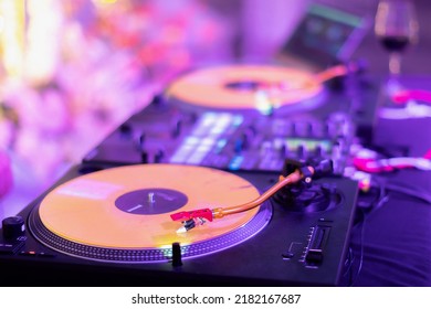 A DJ Table With 2 Turntables And 1 Mixer At The Wedding After Party.