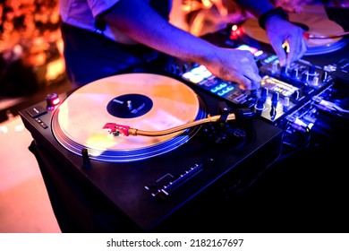 A DJ Table With 2 Turntables And 1 Mixer At The Wedding After Party.