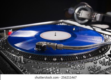 Dj Turn Table With Blue Vinyl Album With Headphones At Nightclub