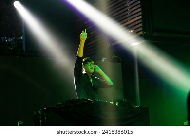 DJ with Turntables at nightclub. Group of diverse young people dancing in night club. Nightlife and disco dance party concept. Fun music festival - Powered by Shutterstock