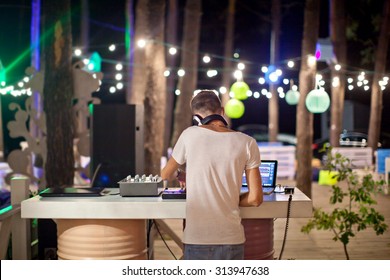 DJ At Work In Outdoor Cafe, Night Photo.