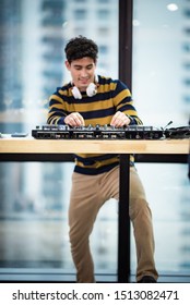DJ working with Digital Mixer & Controller in celebration party