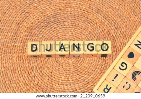 DJANGO word text from wooden cube block letters on braided rattan mats background. Django is a free and open-source web framework, written in Python, which follows the model–view–controller (MVC).