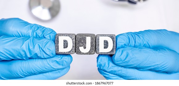 DJD Degenerative Joint Disease - Word From Stone Blocks With Letters Holding By A Doctor's Hands In Medical Protective Gloves