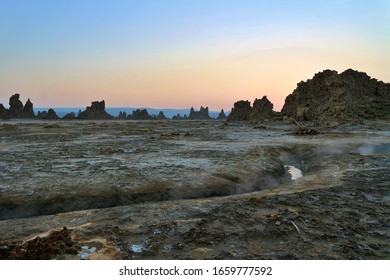 Djibouti Lake Abbe geyser steamy boiling hot water canals rock formations at sunrise dawn dusk desert lac prehistoric surreal landscape