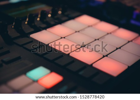 Djs drum machine on concert in night club.Professional disc jockey audio equipment in close up.Midi controller device for beat maker.Produce new hip hop beats with dj electronic musical instrument