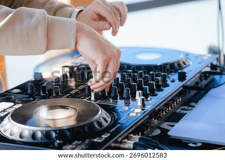 A DJ's hands at work, a close-up of a DJ mixing songs on the console