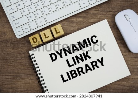 DLL Dynamic Link Library message with keyboard and optical mouse on wooden background