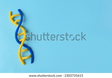 DNA molecule model made of colorful plasticine on light blue background, top view. Space for text