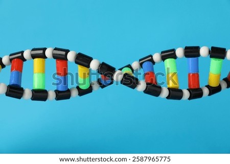 DNA structure model on light blue background, closeup