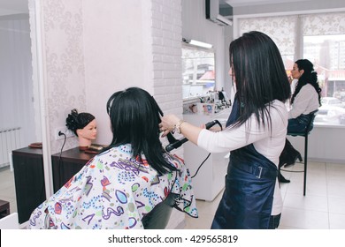 Dneprodzerzhinsk, Ukraine - March 28, 2016: Hairdresser makes hairstyle to the client of beauty salon - Shutterstock ID 429565819