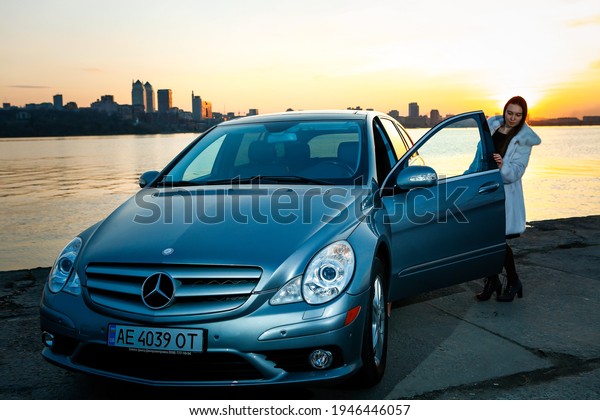 Dnepropetrovsk, Ukraine - 03.15.2021: strong\
independent young woman with a car. The girl opens the door of a\
Mercedes-Benz R\
350.