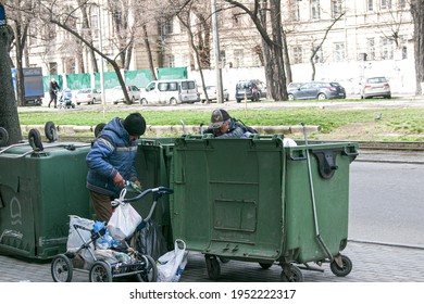 Dnepropetrovsk, Ukraine - 04.06.2021: Dirty Tramps Search For Food And Used PET Bottles In A Trash Bin On The Street. Homeless Men Have No Money Or Housing.