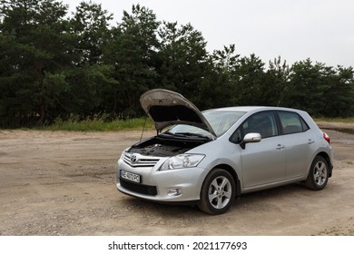 Dnipro, Ukraine - July 30, 2021: Toyota Auris 2012 silver color with open hood. Summer rain