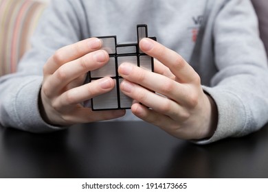 Dnipro, Ukraine - May 11, 2020 - Boy Solving Mirror Cube. Child Hands With Cube Puzzle. Close Shot.