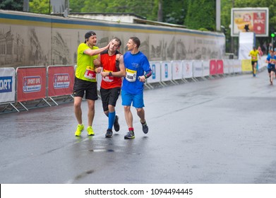 DNIPRO, UKRAINE - MAY 20, 2017: Friendly Participants Helping Other Guy Who Is Loosing Consciousness On The Finish Line During Of The 