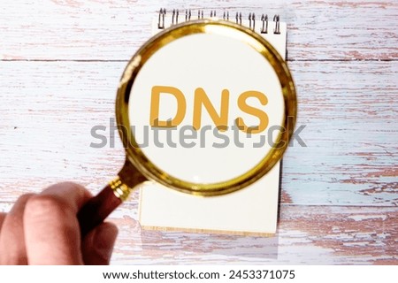 DNS Domain Name System Server Decentralized naming system for computers, devices, services, other resources An inscription was found using a magnifying glass. Concept photo