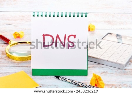 DNS Domain Name System Server Decentralized naming system for computers, devices, services, other resources in a notebook next to a calculator, magnifying glass, pencil and crumpled paper