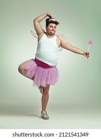 I do ballet. An overweight man comically dressed-up in a pink fairy costume doing ballet.
