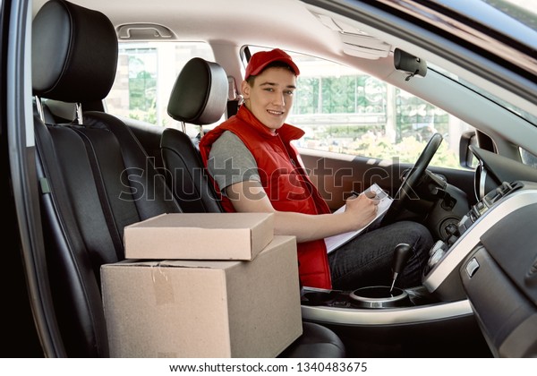 Do the best you can, with what you can, while\
you can, and success in inevitable. Smiling delivery man sitting in\
the car as a driver. Side\
view