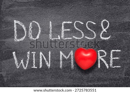 do less and win more phrase written on chalkboard with red heart symbol