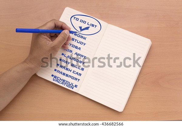 To Do List Circled\
Check : work, study, yoga, dr appt., laundry, pay bills, wash car,\
passport, schedule vacation  writing in Notebook  with blue felt\
tip pen on wood desk