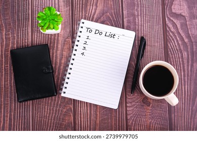 To Do List on notebook with cup of coffee, pen, and wallet on wooden desk. Top view of workspace for productivity, planning, and morning routine concept.