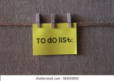 To do list text on a yellow notes with three clips
