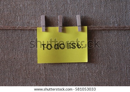 To do list text on a yellow notes with three clips