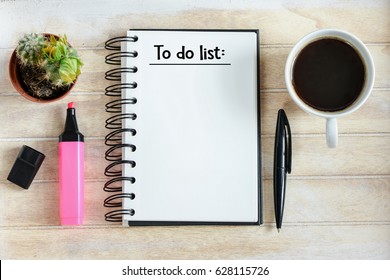 To do list written in a notebook / Notebook with an to do list on wooden desk with cup of coffee  - Shutterstock ID 628115726
