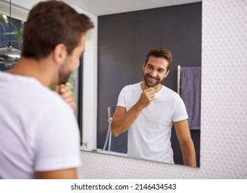 I do look good with a beard though. Cropped shot of a handsome man looking at himself in the mirror whilst touching his beard at home.