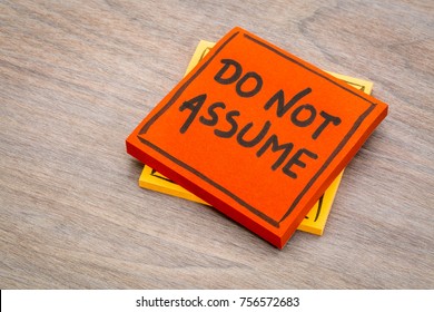 Do not assume advice or reminder handwriting on a sticky note against grained wood - Shutterstock ID 756572683