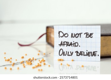 Do not be afraid, only believe, handwritten text with mustard seeds and holy bible. Close-up. Copy space. Faith in God Jesus Christ, biblical concept.