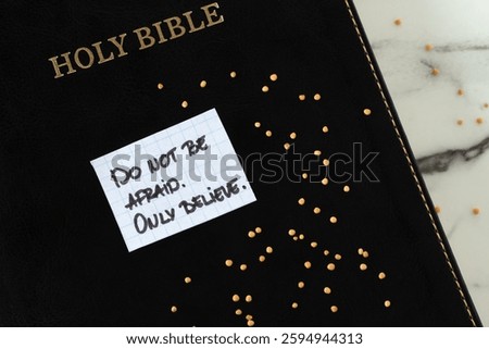 Do not be afraid, only believe, inspirational handwritten quote with mustard seeds and holy bible book. Top view. Christian biblical concept of faith in God Jesus Christ.