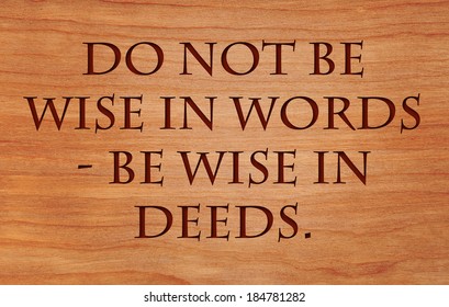 Do not be wise in words - be wise in deeds - motivational Jewish Proverb on wooden red oak background