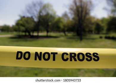 Do Not Cross Police Tape Is Seen In A Park With Trees.