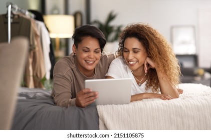 Do Not Disturb Our Quality Time. Shot Of A Young Lesbian Couple Using A Tablet While Relaxing In Their Bedroom.