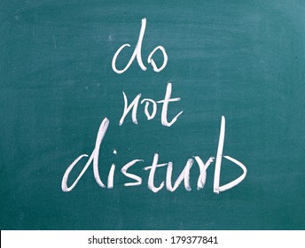 Do Not Disturb Written By Hand In White Chalk On A Used Blackboard 