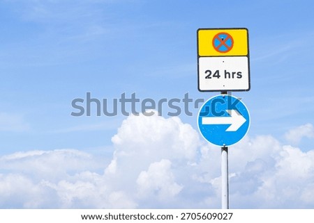 Do Not Enter or no entry blue and red cross aluminum square yellow and letters 24 hrs on white sign with circle arrow signs with blue sky cloud white is background. Regulatory for vehicular traffic.