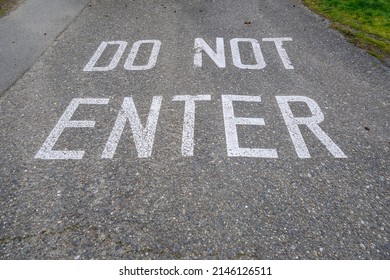 Do Not Enter Stenciled On A Sloping Driveway In Big White Block Letters
