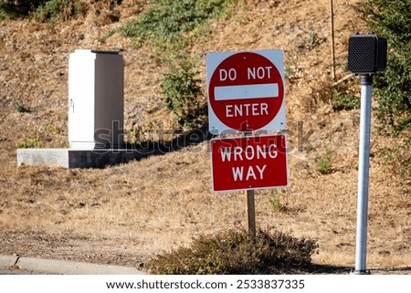 Do Not Enter Wrong Way red metal sign on the side of a road, at the entrance to a highway
