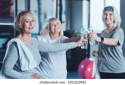 Do Not Forget About Hydration. Team Of Three Senior Ladies Standing In A Circle And Looking Into The Camera With Cheerful Smiles On Their Face After Finishing Their Exercise Class.