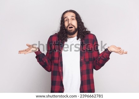 I do not know. Unaware perplexed bearded man spreads palms sideways, has no idea what to do, thinks how to act in troublesome situation. Indoor studio shot isolated on gray background.