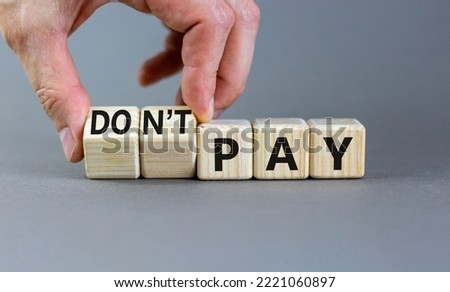Do not pay symbol. Concept words do not pay on cubes. Businessman hand. Beautiful grey table grey background. Business, financial crisis and do not pay concept. Copy space.
