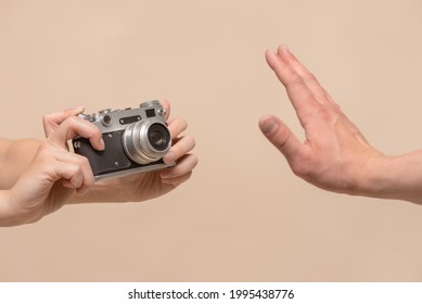 Do Not Shoot Concept. No Photo. One Person With Photo Camera In Hand And Stop Gesture By Another Hand Close Up. Personal Space.