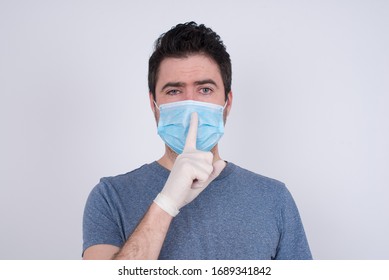 Do Not Speak Too Loud, Please! Emotional Surprised Man Makes Hush Gesture, Asks Be Quiet Wears Face Mask And Gloves. Protection Against Contagious Disease.